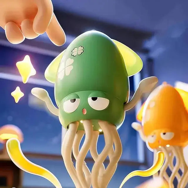 Cartoonish green jellyfish toy with a hand reaching towards it, set against a blurred indoor background.