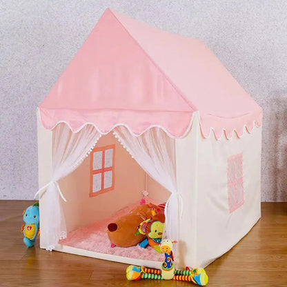 Pink children's play tent with toys on a wooden floor against a gray wall.