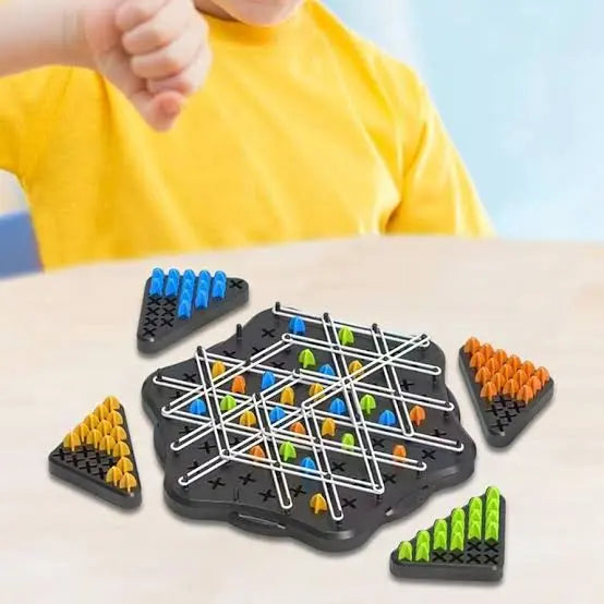 Board game with colorful pegs on a table, child in yellow shirt in the background