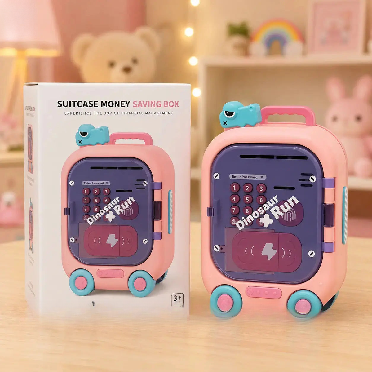 Pink suitcase-shaped money saving box with dinosaur design next to its packaging on a wooden surface